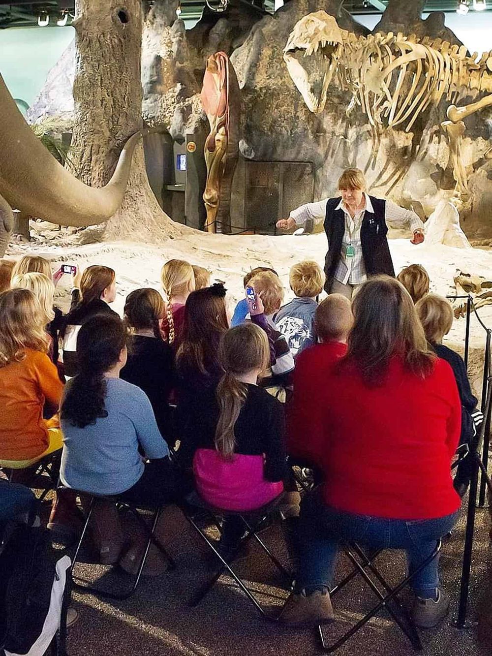 Dinosaurs exhibit at Quest For Directions museum with children attending an engaging educational presentation.