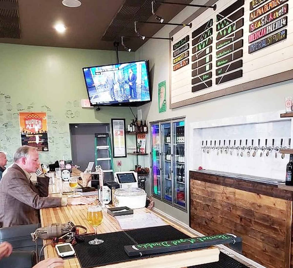 Modern pub interior with TV, craft beers, and drink menu at QuestForDirections, a popular local bar.