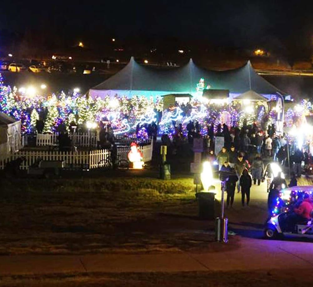 Colorful Christmas lights and festive decorations at nighttime outdoor holiday event.