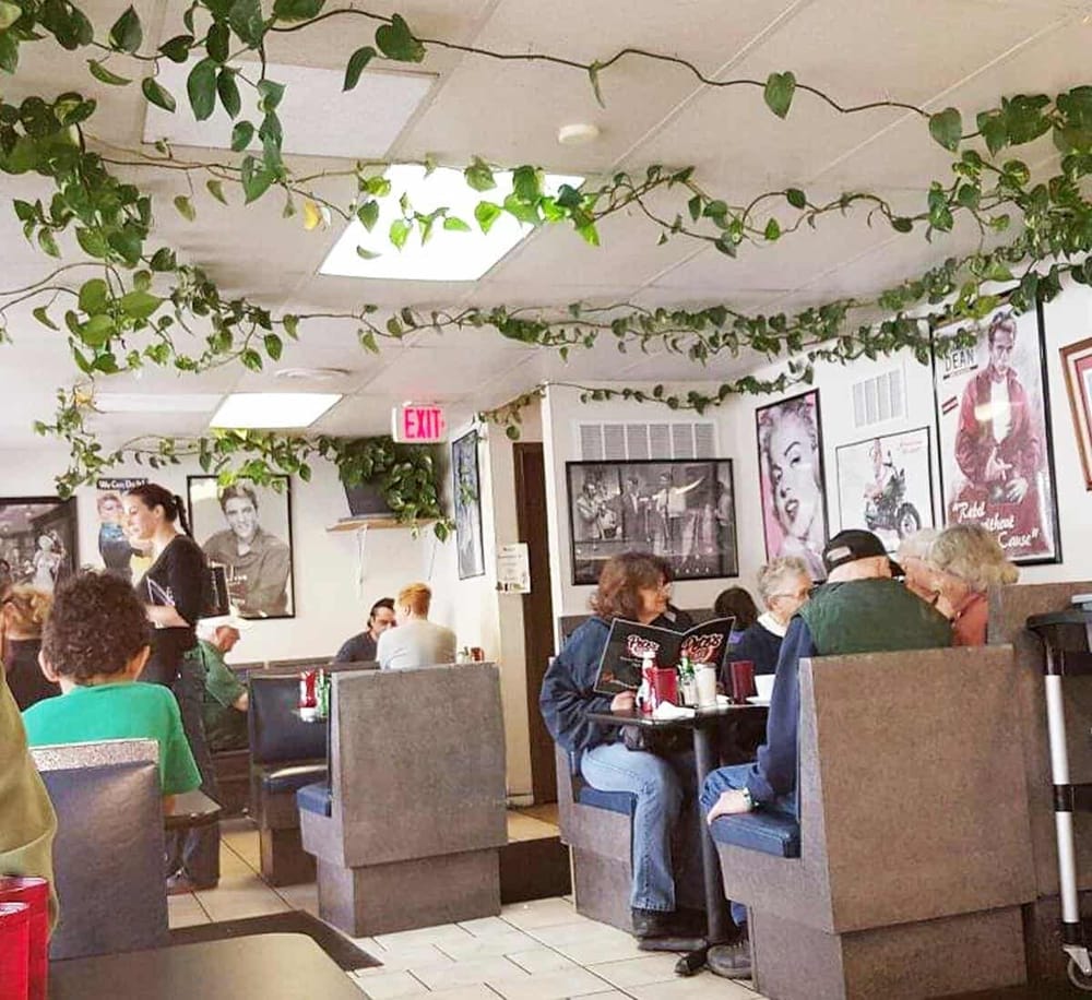 Colorful diner interior with vintage decor, customers enjoying meals, and nightlife ambiance at QuestForDirections.