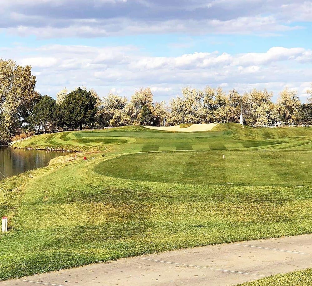 Vibrant golf course with lush green grass, sand traps, and water hazards, perfect for golf enthusiasts.