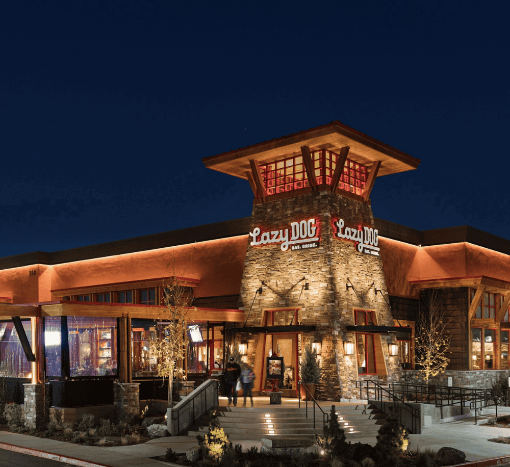 1. Modern rustic Lazy Dog restaurant exterior at night with illuminated signage and welcoming entrance.