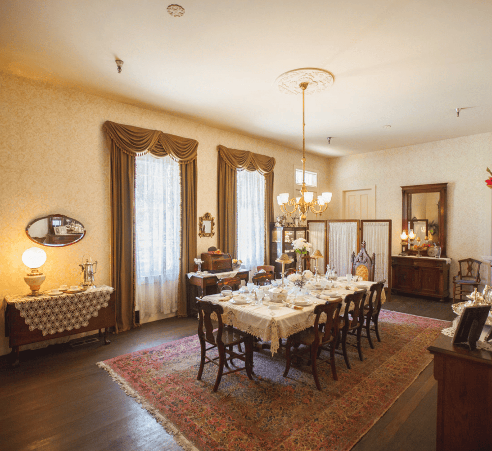Elegant vintage dining room with ornate chandelier and antique furniture, ideal for historical event space.