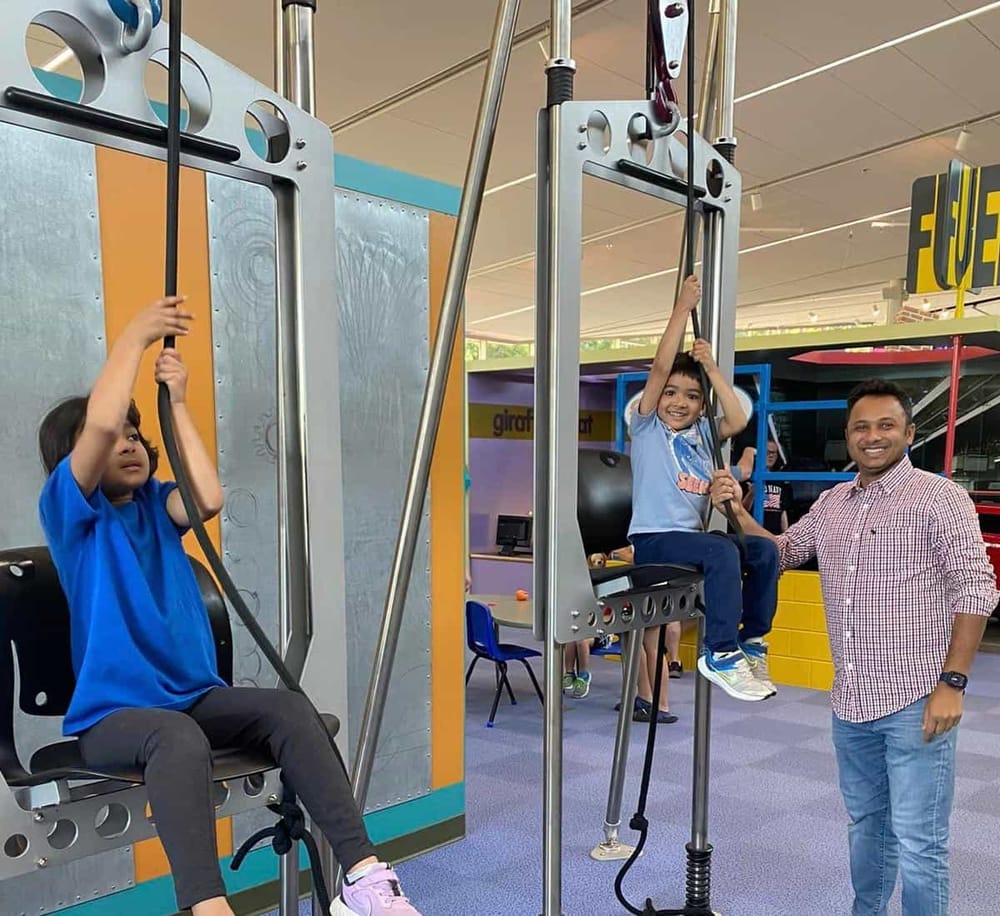 Children playing on a climbing and swinging play area at QuestForDirections indoor amusement park.