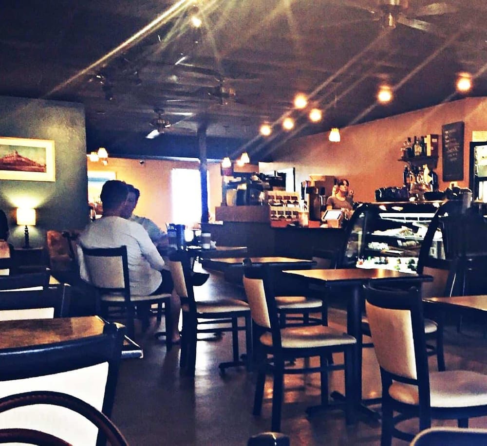 Cozy coffee shop interior with customers and barista, inviting space for relaxing and enjoying beverages.