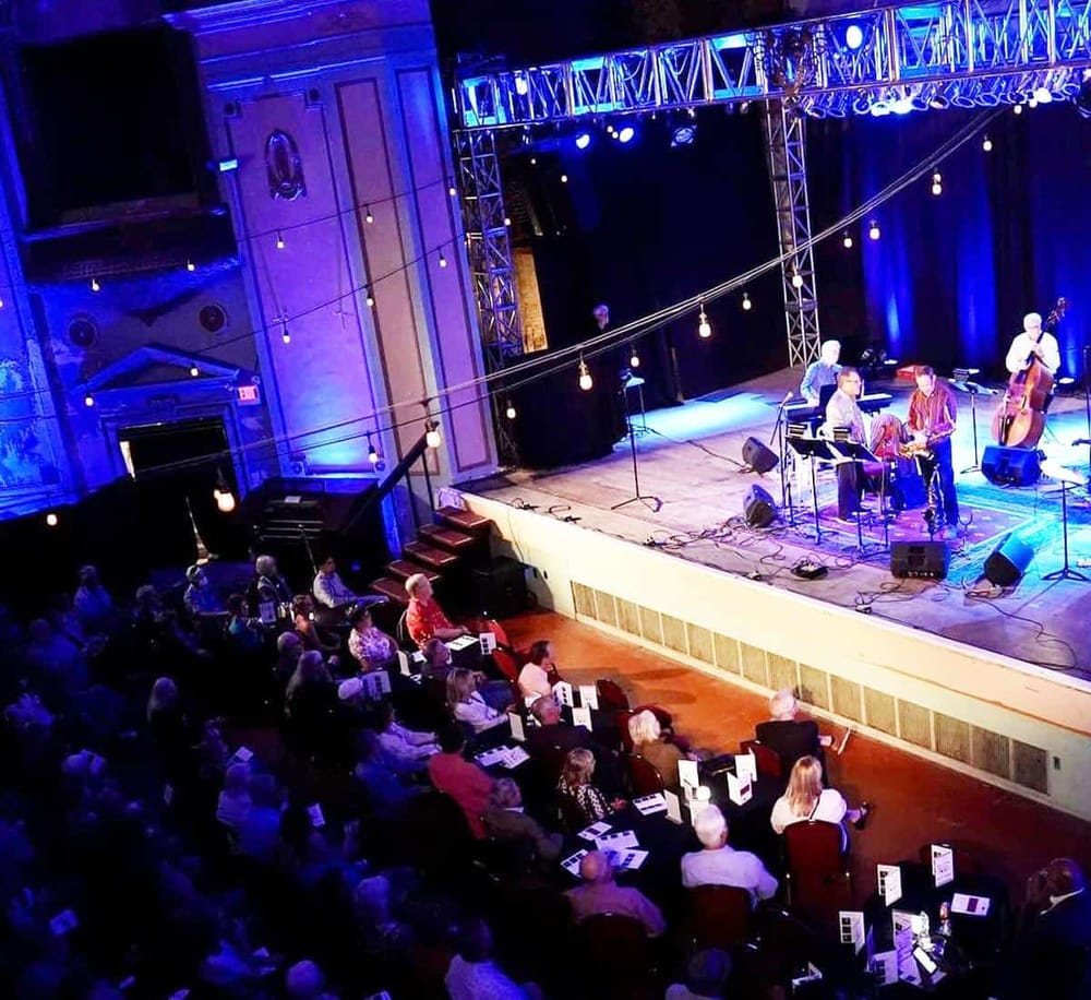 Live jazz band performing at a music venue with an audience enjoying the concert.