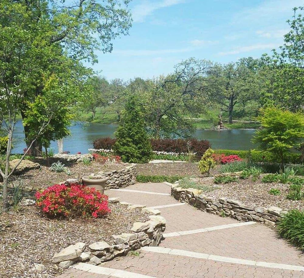 Tranquil lakeside park with flower gardens and scenic walking paths, perfect for outdoor relaxation and nature exploration.