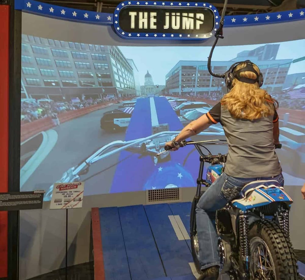 Thrill-seeker riding a motorcycle simulator at QuestForDirections fun center.
