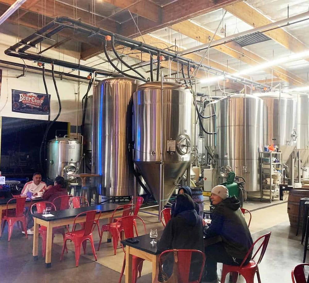 Brewing tanks at a craft brewery, showcasing beer production process and tasting area.