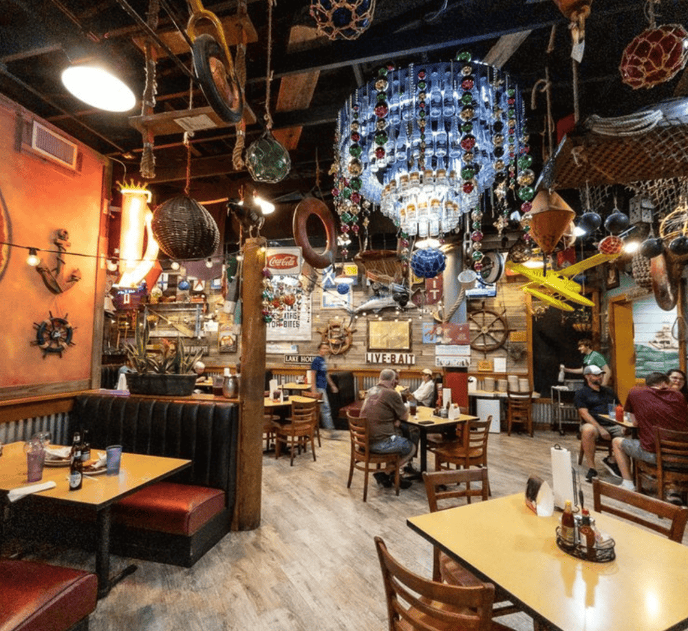 Boating-themed restaurant interior with nautical décor, hanging ornaments, and cozy atmosphere.