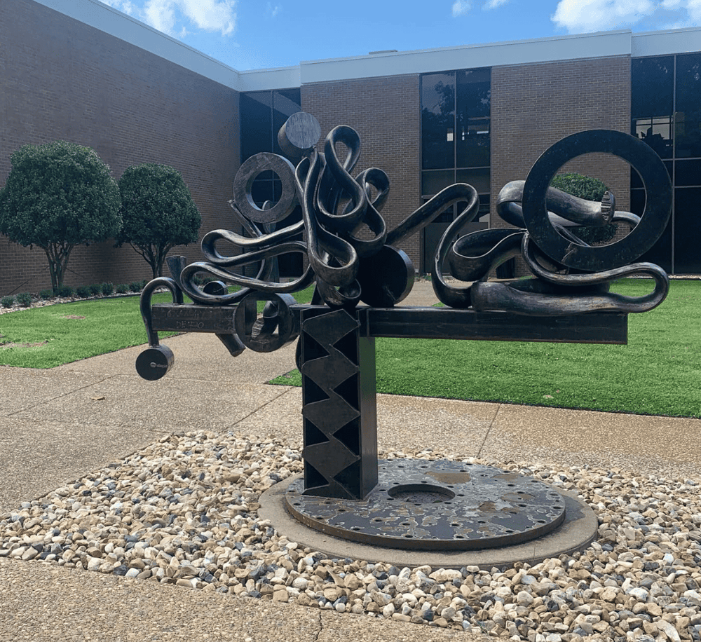 Intricate metal abstract sculpture outside Quest for Directions building.