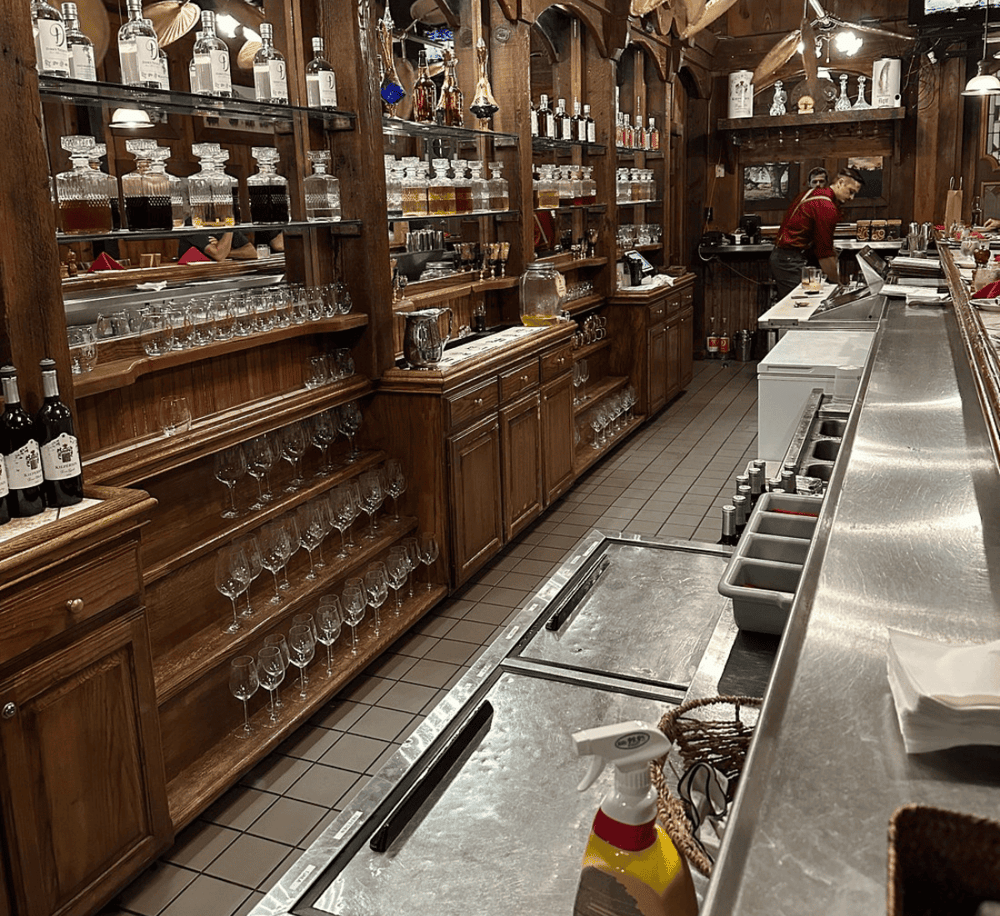 Bar with wooden shelves and glassware at QuestForDirections restaurant.