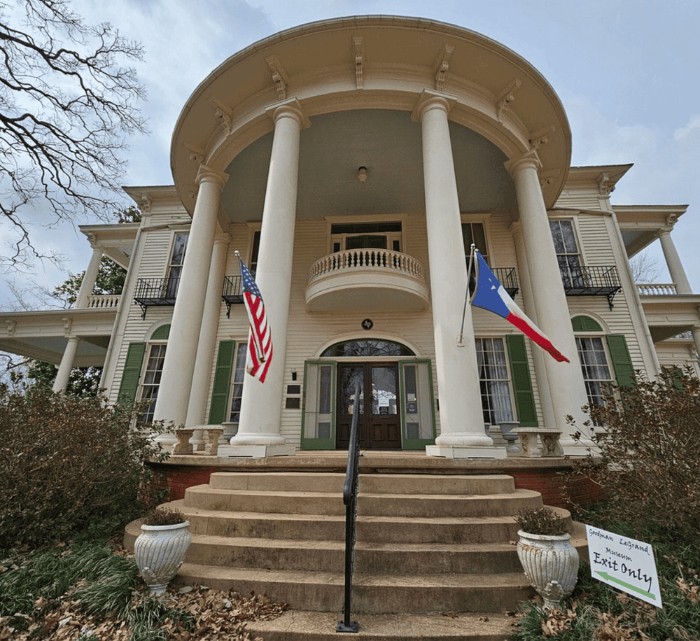Flagged historic house with grand columns and staircase, part of QuestForDirections historical travel guides.