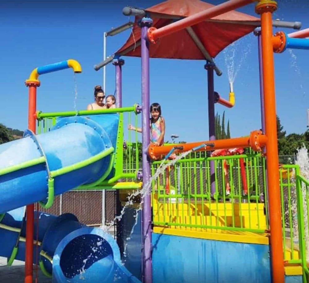 Colorful water playground with slides and kids enjoying water fun in the sun.