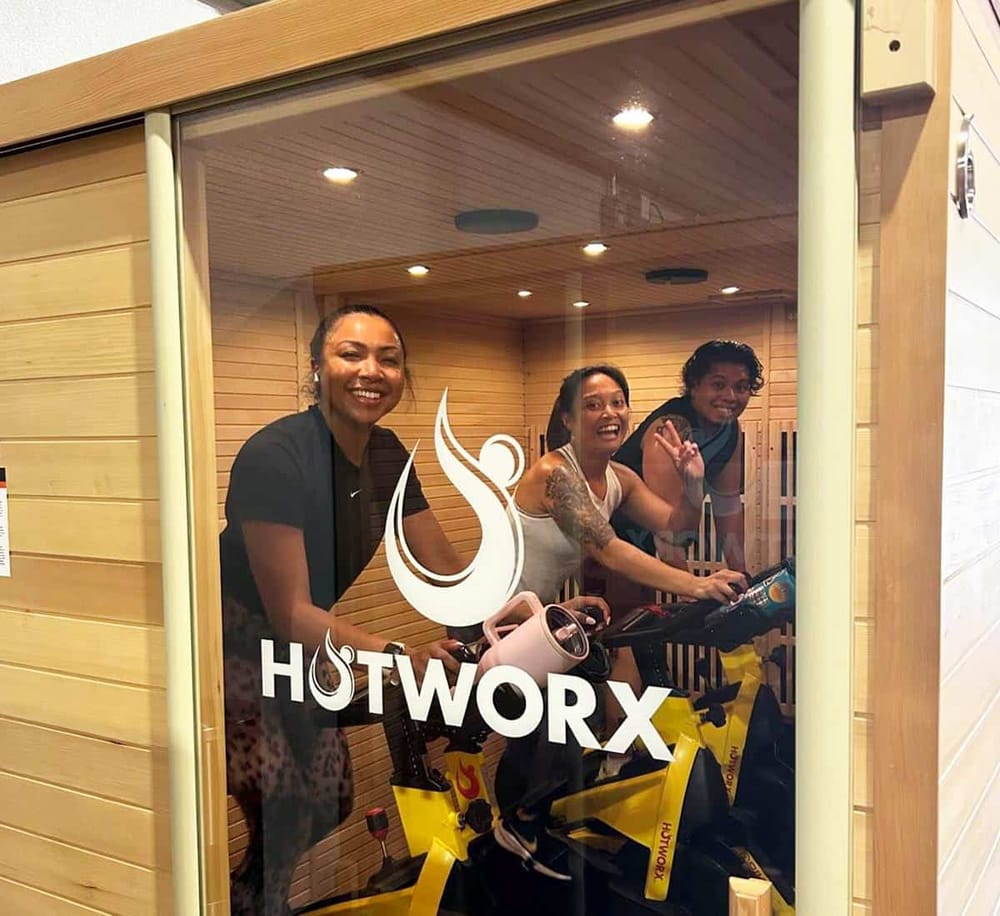 Vibrant indoor cycling class at Hotworx fitness studio with energized participants.