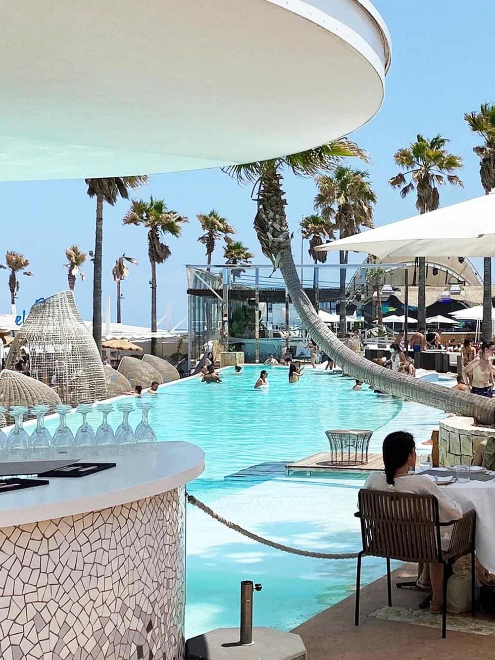 Luxurious oceanfront pool at Quest For Directions resort with palm trees and beach views.