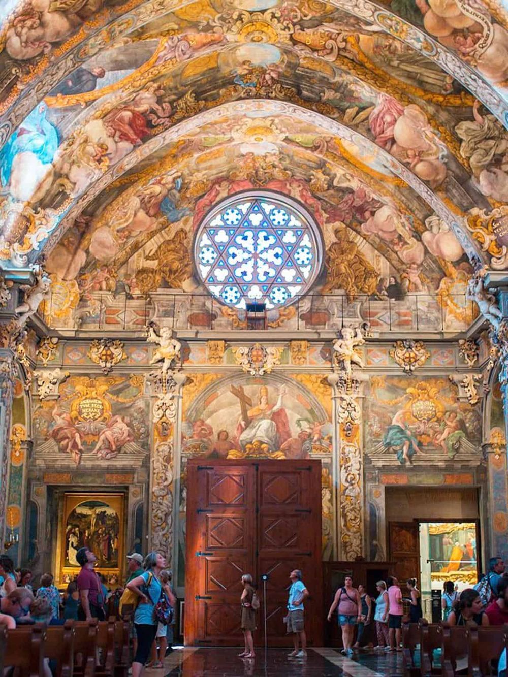 Vatican Sistine Chapel interior with religious artwork, frescoes, and stained glass.