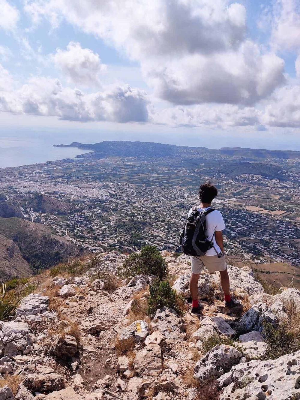 Scenic mountain view with hiker overlooking city and coastline, adventure travel, outdoor exploration, nature experience, QuestForDirections.