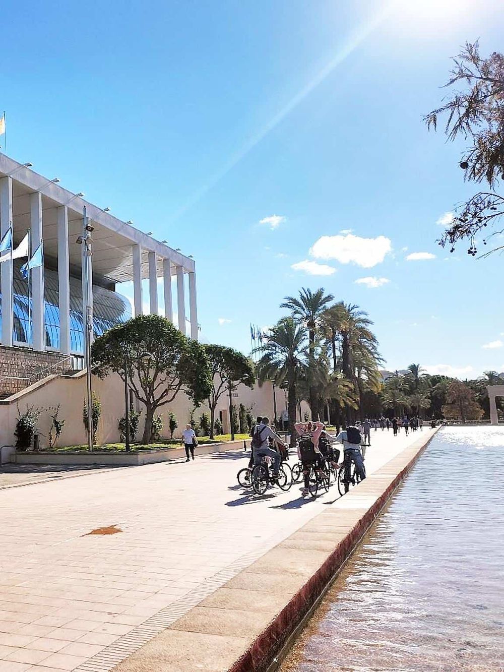 Beautiful outdoor scene at Quest for Directions location with people cycling by the water.