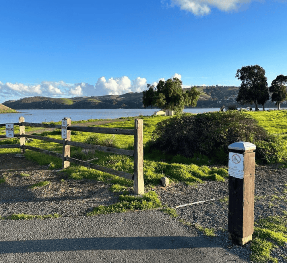 Tranquil lakeside park with scenic water views, trees, and outdoor recreation areas. Ideal for relaxation and outdoor activities.