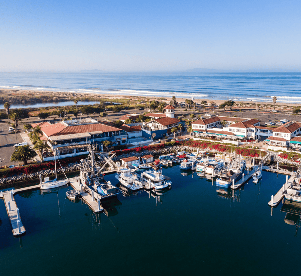 Harbor and marina at the beach with boats and seaside restaurants, perfect for vacation and travel planning.