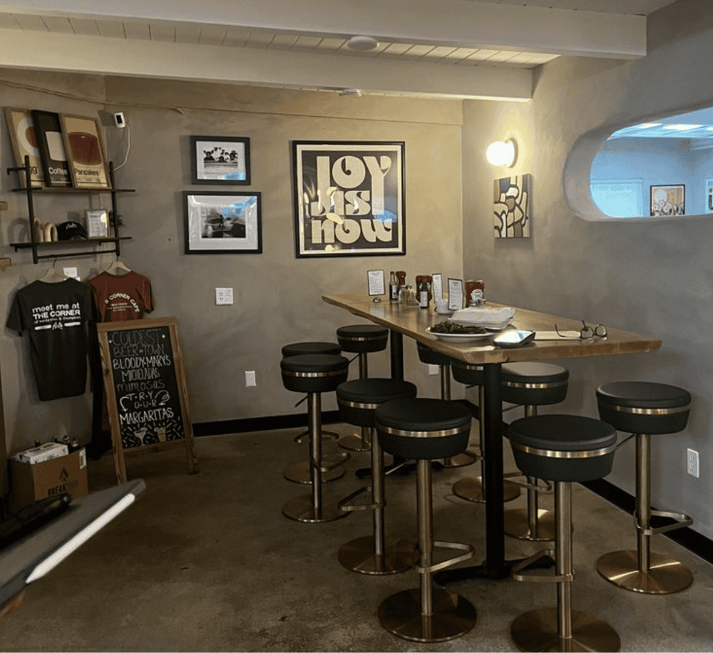 Cozy modern restaurant interior with bar seating, wall art, and casual decor. Ideal for dining and social gatherings.