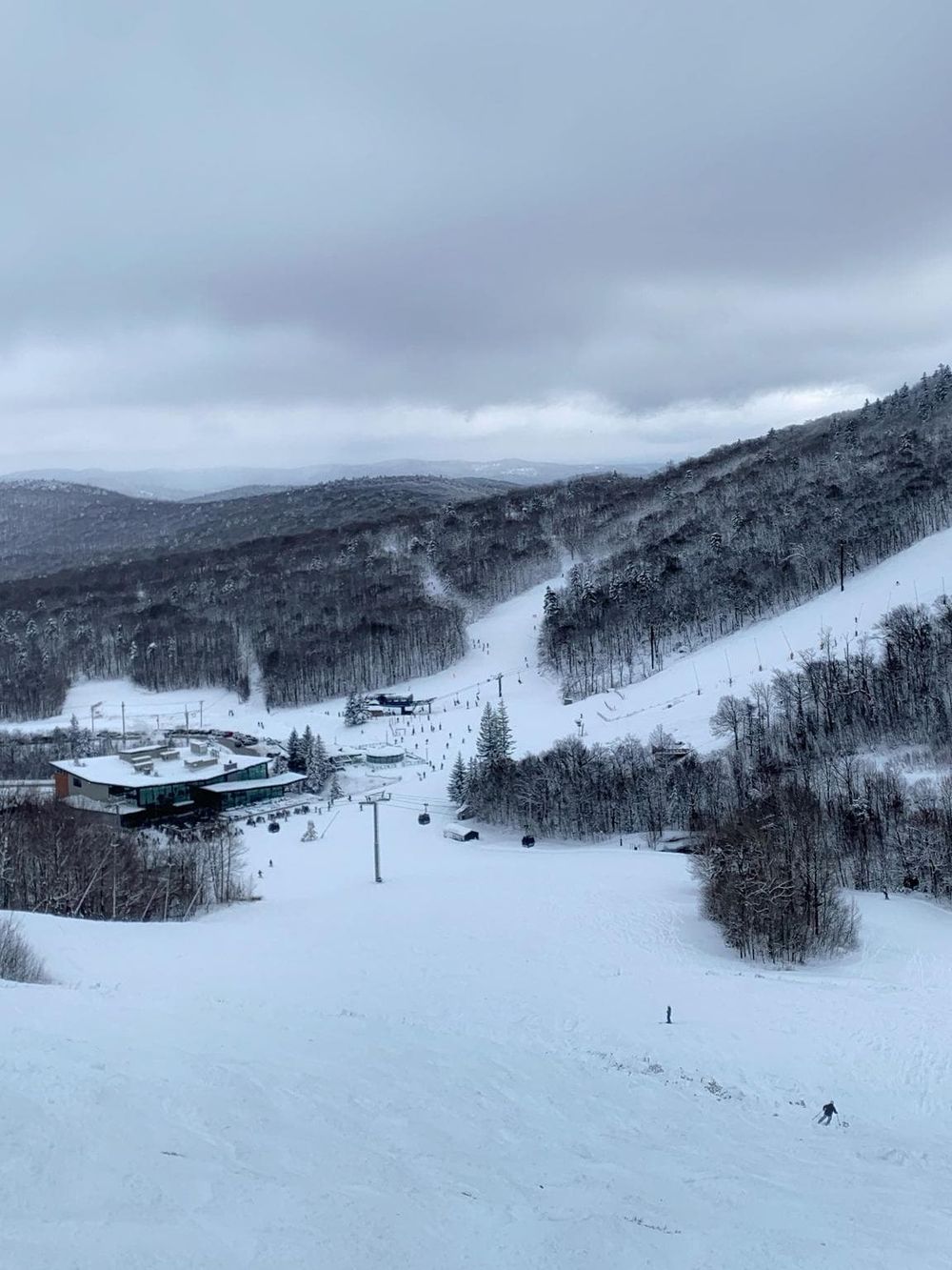 Snowy ski resort with slopes, chairlifts, and mountain views during winter.