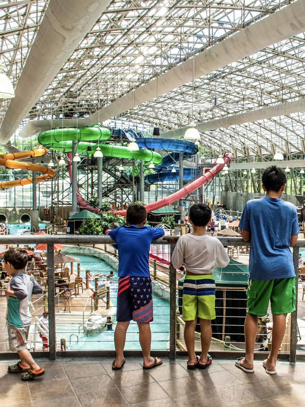 Indoor water park with colorful water slides and family enjoying aquatic fun.