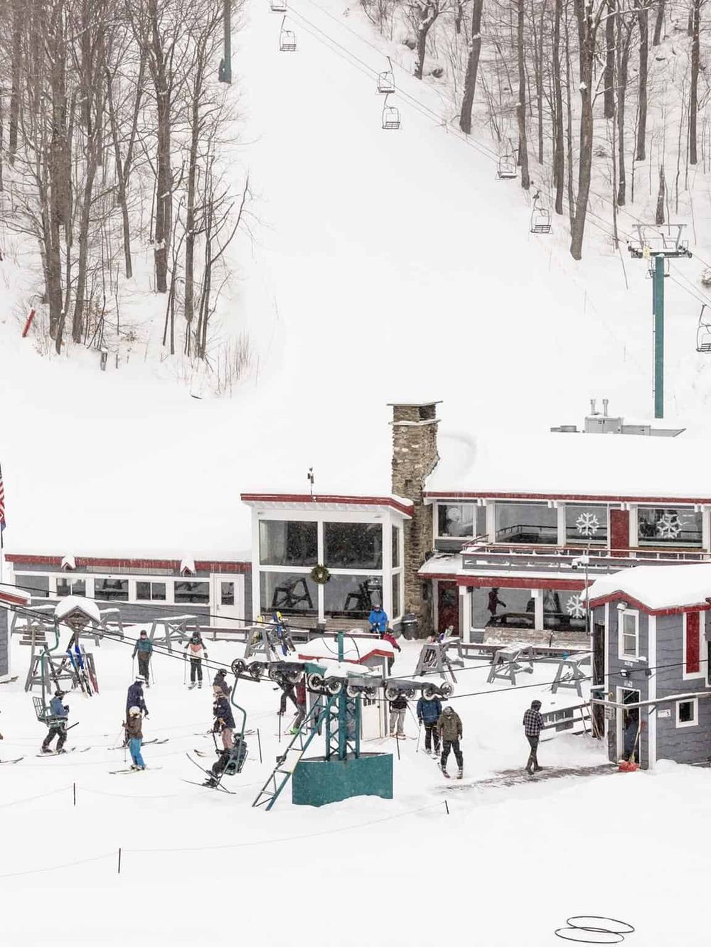 Snowy ski resort with chairlifts and a ski lodge in the mountains.