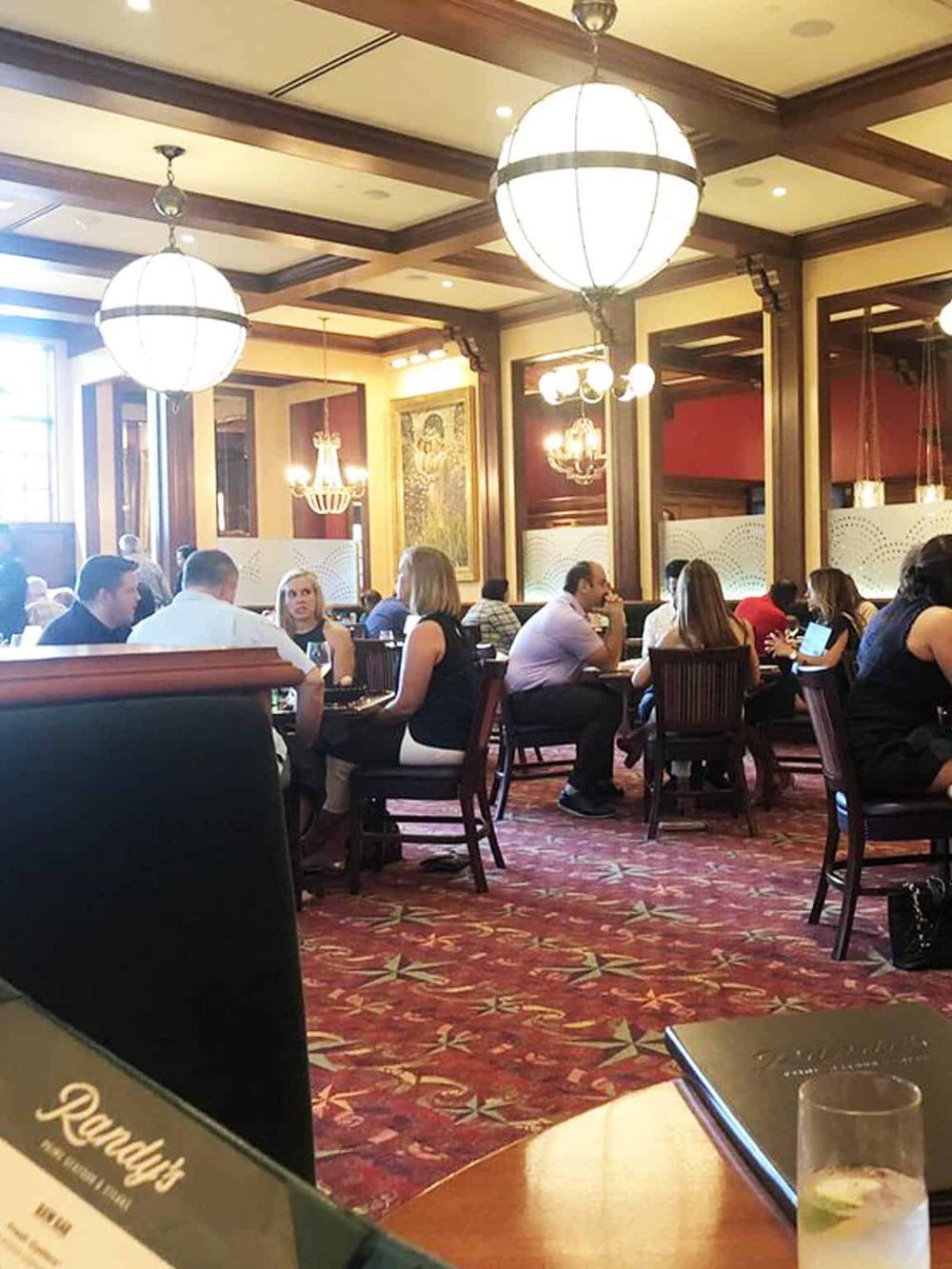 Elegant restaurant interior with warm lighting and diverse guests enjoying meals and conversations.