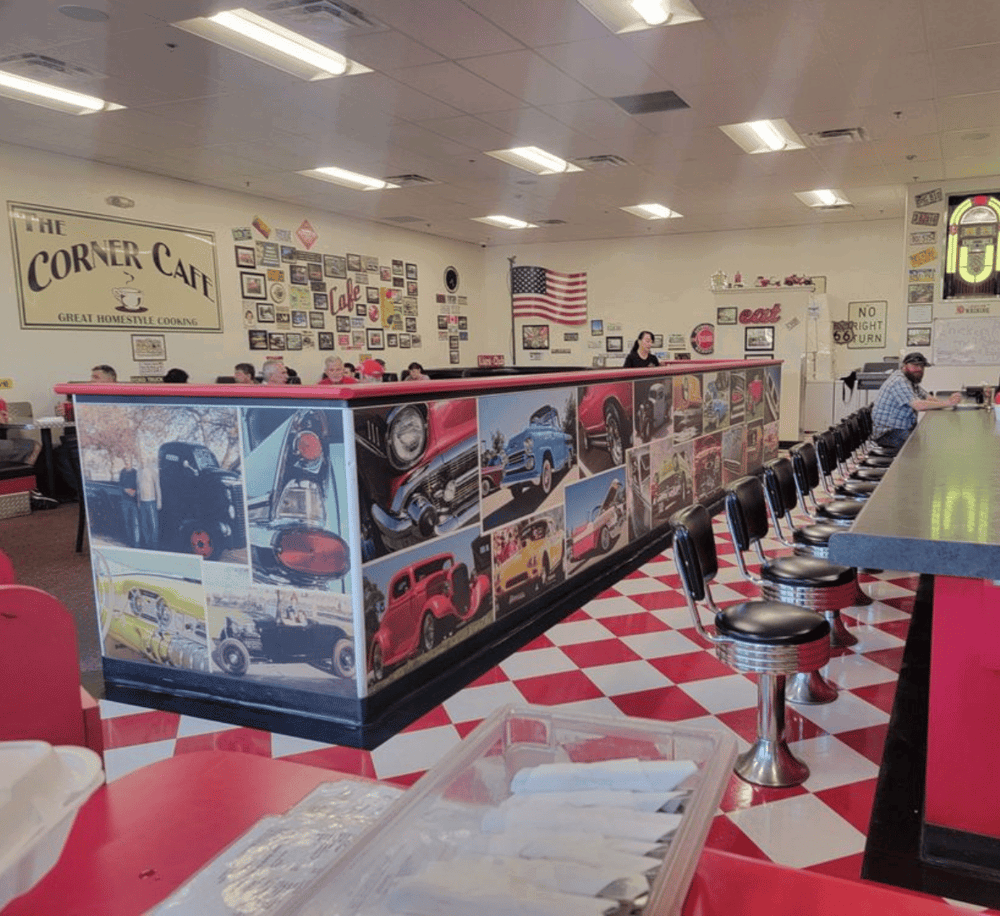 Classic American diner with vintage car decor, red and white checkered floor, nostalgic atmosphere, and retro photos.