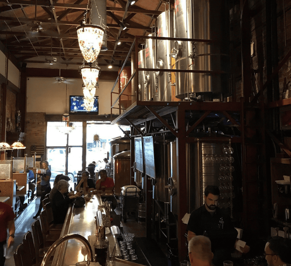 1. Craft brewery interior with brewing tanks and bar, welcoming atmosphere for beer lovers and food pairing.