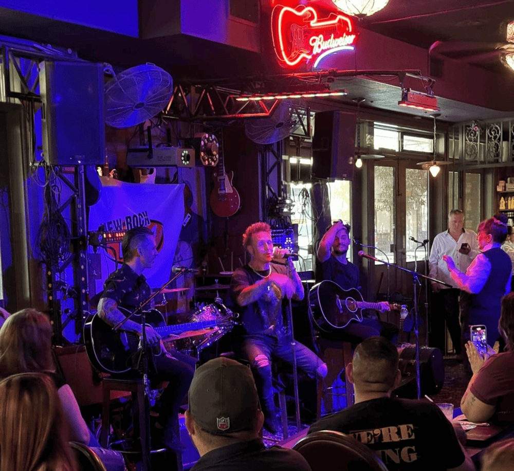 Live rock band performance at a music venue with guitars and musical equipment.