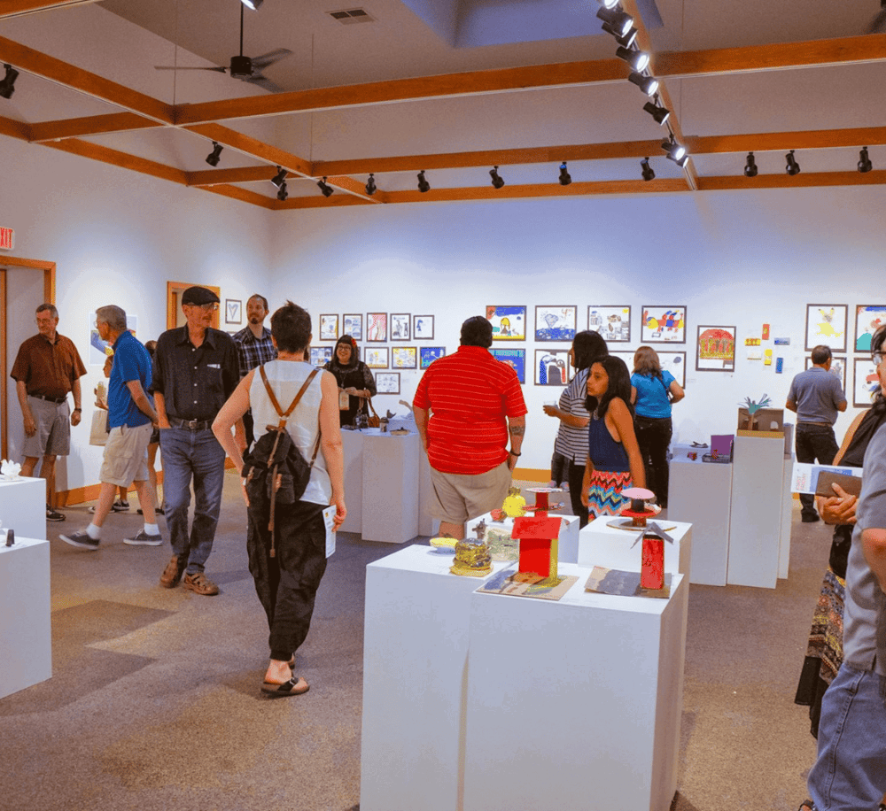 Art gallery exhibition featuring vibrant artwork and creative sculptures, showcasing diverse artistic styles and talents.