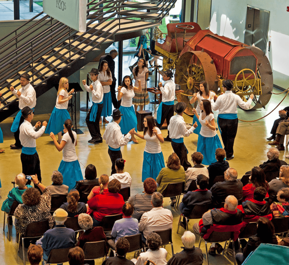Colorful traditional dance performance at QuestForDirections cultural event in an exhibit hall.