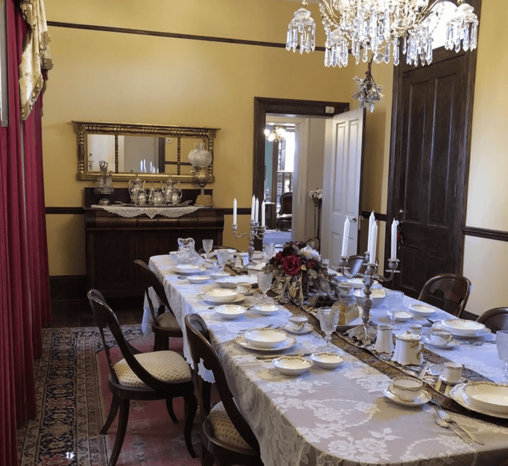 Elegant vintage dining room with antique table setting and chandelier, perfect for classic dinner parties.