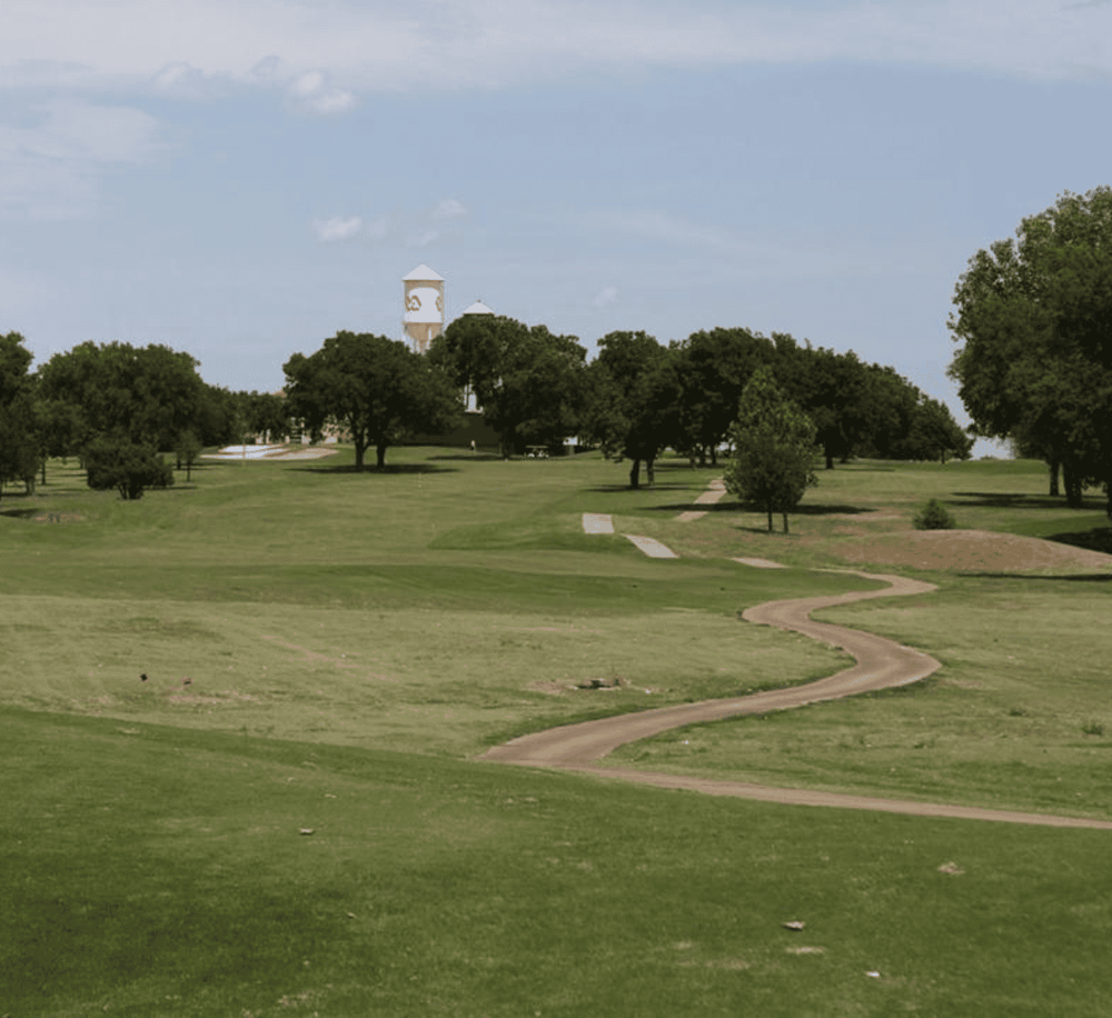 Lush golf course with winding path and scenic trees, perfect for outdoor recreation and relaxation.