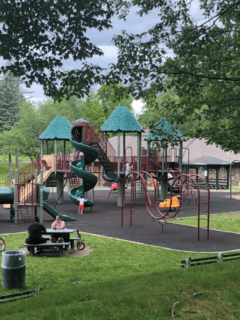 Colorful playground with slides and climbing structures in a park during daytime.