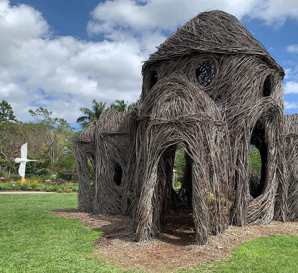 Unique outdoor art sculpture made of intertwined branches, perfect for nature lovers and art enthusiasts.