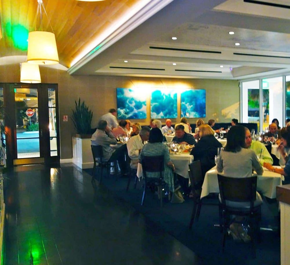 Elegant restaurant interior with diners enjoying meals in a modern, stylish setting.