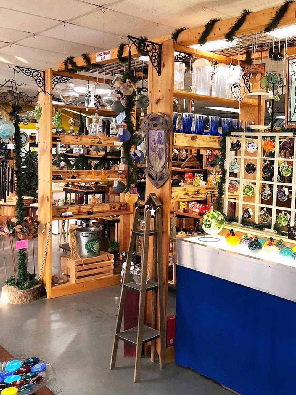 Colorful handmade glass ornaments inside an artisan craft store, showcasing unique holiday decorations and glass art.