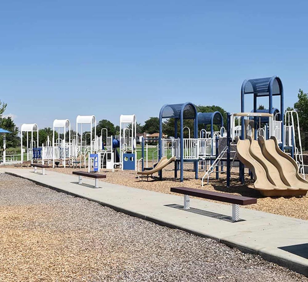 Colorful playground equipment for kids at a community park, featuring slides and climbing structures.