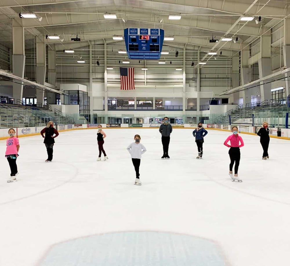 Ice skating rink with children and instructor, indoor ice hockey arena, family-friendly fun at QuestForDirections.