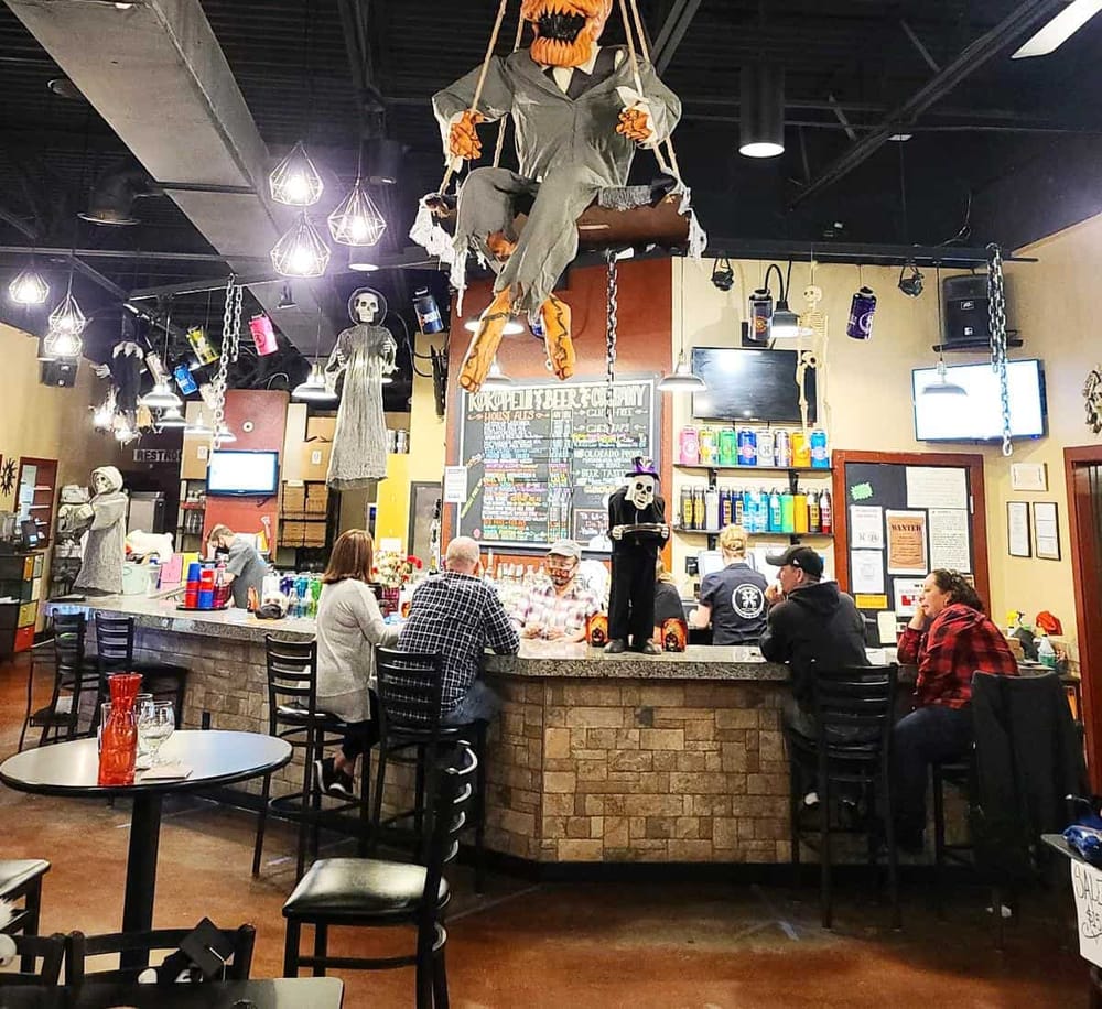Scary Halloween-themed bar décor with hanging skeletons and spooky decorations at QuestForDirections pub.