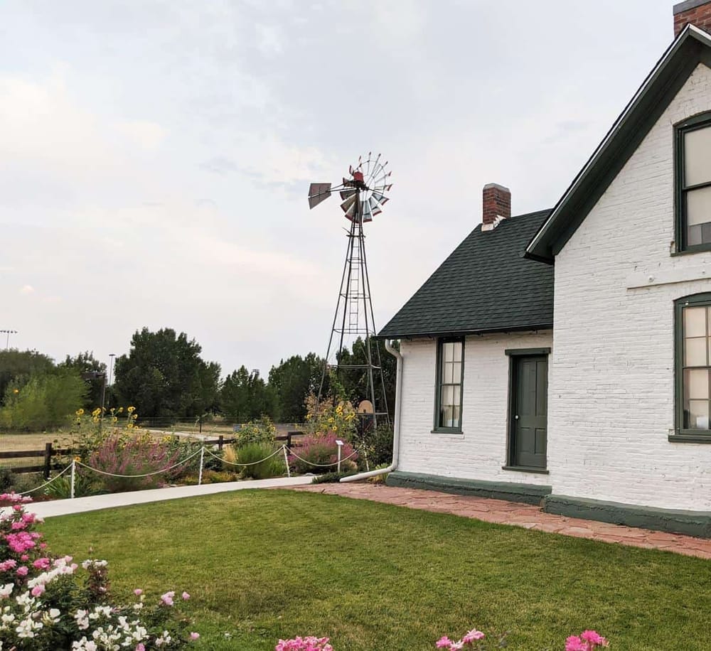 Vintage farmhouse with garden and windmill, charming country scenery, rural landscape photography, Quest For Directions.