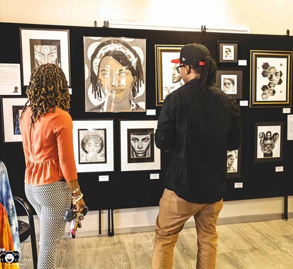 Vibrant art gallery showcasing diverse portrait artwork, visitors admiring and engaging with pieces.