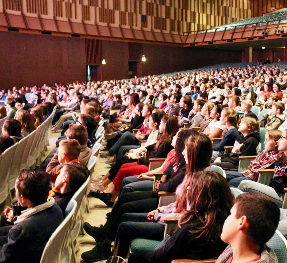 Vibrant conference audience attending a presentation in a large auditorium.