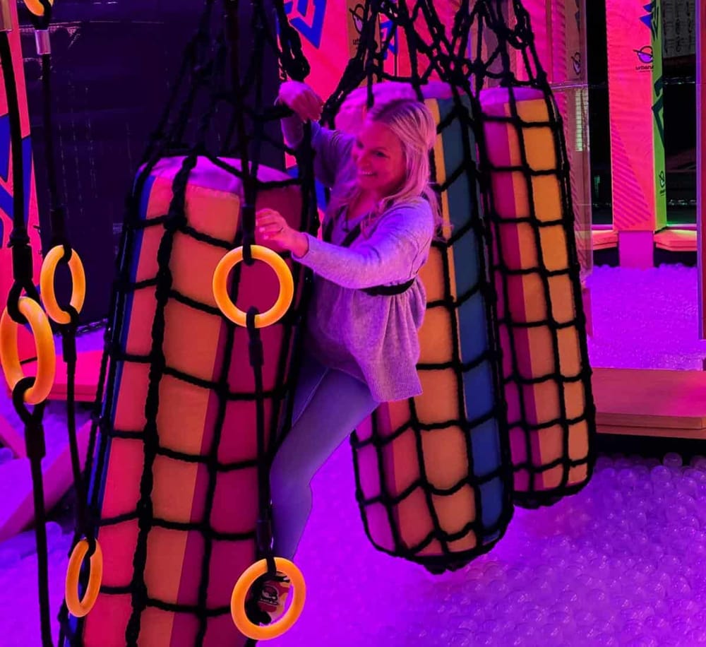 Bright indoor adventure park with colorful play structures and gymnastic rings for kids' entertainment.