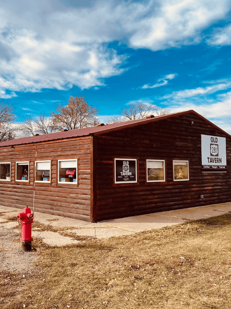 Cozy wooden tavern building with outdoor signage, Route 281, Alaska style, inviting local dining experience.