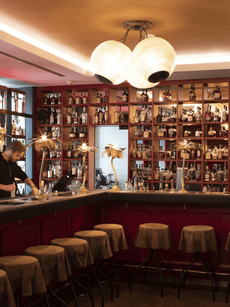 Luxurious bar interior with illuminated bottles, cozy seating, and stylish decor | QuestForDirections.